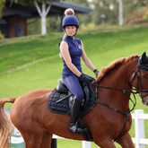 Rider wears the Shires Aubrion Team Sleeveless Base Layer in Midlnight